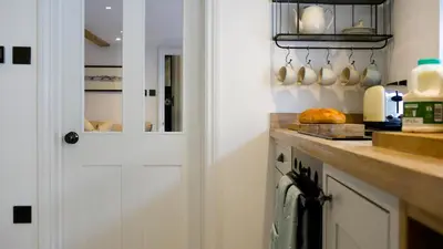 a kitchen with a white door and a counter at Padstow Escapes - Captains Cottage in Padstow