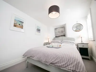 a white bedroom with a bed with a tray on it at Padstow Escapes - Captains Cottage in Padstow