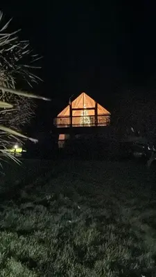 a large building with a lit up roof at night at Lake View Lodge in Saint Columb Major