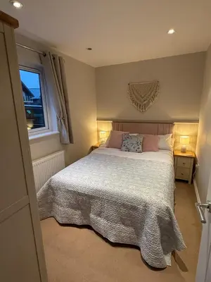 a bedroom with a large bed and a window at Lake View Lodge in Saint Columb Major