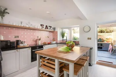 a kitchen with a table with a bowl of vegetables on it at Maris Cottage in St. Agnes