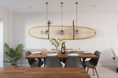 a dining room with a table and a chandelier at Maris Cottage in St. Agnes