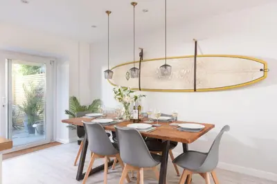 a dining room with a wooden table and chairs at Maris Cottage in St. Agnes