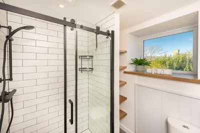 a bathroom with a shower and a window at Maris Cottage in St. Agnes