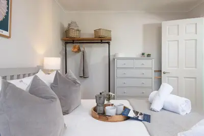 a bedroom with a bed with pillows and a dresser at Maris Cottage in St. Agnes