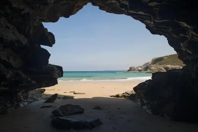 a view of a beach with the ocean through a cave at Maris Cottage in St. Agnes