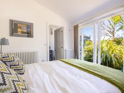 a bedroom with a bed and a large window at Bay Tree in Crackington Haven