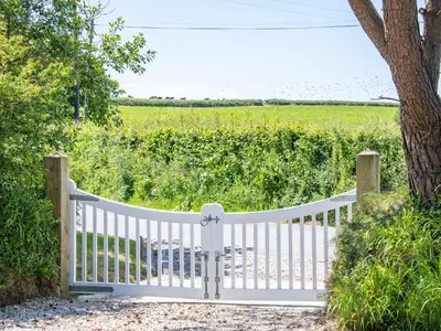 a white fence with a field in the background at Bay Tree in Crackington Haven