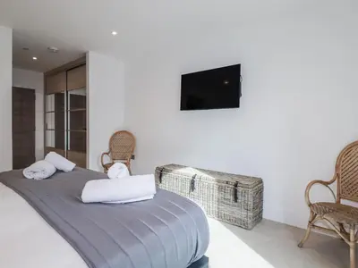 a bedroom with a bed with a tv on the wall at 13 Cliff Edge in Newquay