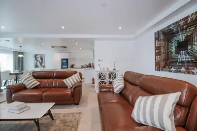 a living room with a leather couch and a table at 13 Cliff Edge in Newquay