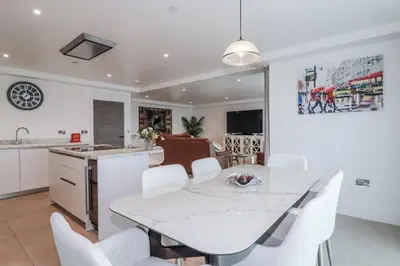 a kitchen and dining room with a white table and chairs at 13 Cliff Edge in Newquay