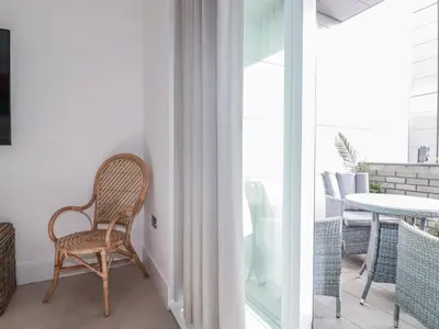 a rattan chair sitting on a balcony next to a table at 13 Cliff Edge in Newquay