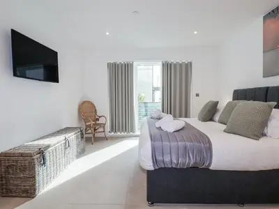 a bedroom with a large bed and a television at 13 Cliff Edge in Newquay