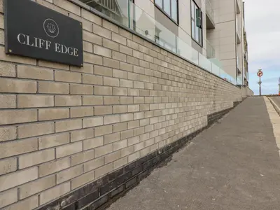 a brick building with a sign on the side of it at 13 Cliff Edge in Newquay
