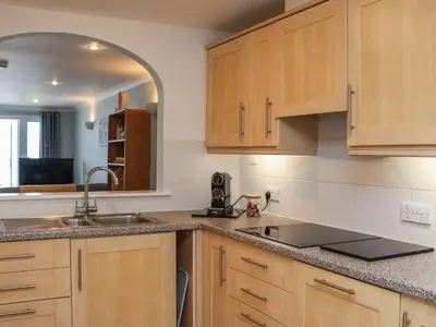 a kitchen with wooden cabinets and a sink at Ivory in St Ives