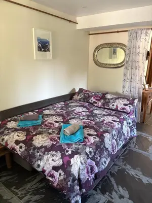 a bedroom with a bed with a floral bedspread at The Mill'ouse in Launceston