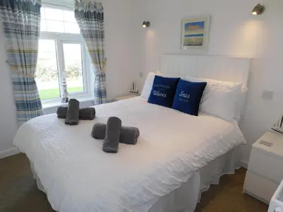 a bedroom with a white bed with two pillows on it at Primrose Cottage, spacious 4 bed house near Newquay in Newquay