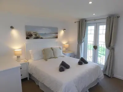 a bedroom with a white bed with two pillows on it at Primrose Cottage, spacious 4 bed house near Newquay in Newquay
