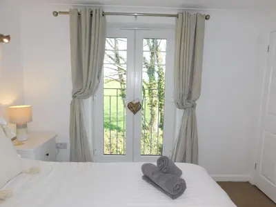 a bedroom with a bed with towels on it at Primrose Cottage, spacious 4 bed house near Newquay in Newquay