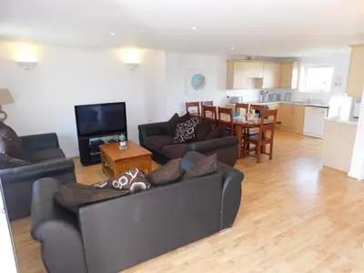 a living room with two couches and a kitchen at Primrose Cottage, spacious 4 bed house near Newquay in Newquay