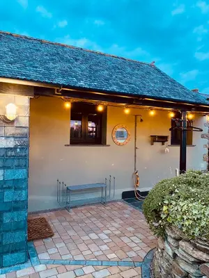 a house with a bench in front of it at Sea View at Widemouth Bay - 3 bedroom cottage in Poundstock