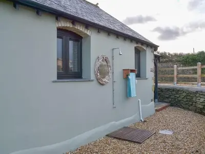 a white house with a wreath on the side of it at Sea View at Widemouth Bay - 3 bedroom cottage in Poundstock