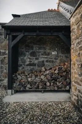 a pile of fire wood under a brick wall at Sea View at Widemouth Bay - 3 bedroom cottage in Poundstock
