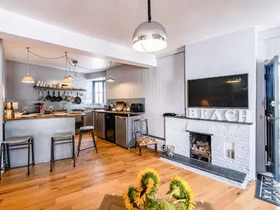 an open kitchen and living room with a fireplace at Pibbies in Port Isaac
