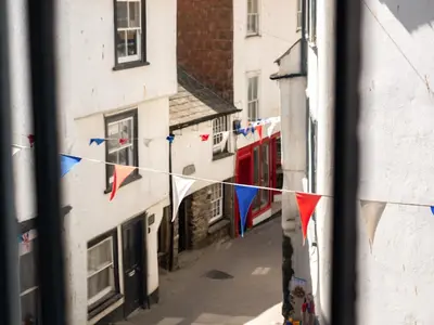 a view from a window of a street with flags at Pibbies in Port Isaac