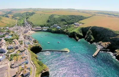 an aerial view of a beach with boats in the water at Pibbies in Port Isaac