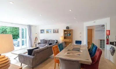 a living room with a table and a couch at Trewhiddle Retreat V9 by Together Travel - Luxury 4-Bedroom Villa in St Austell