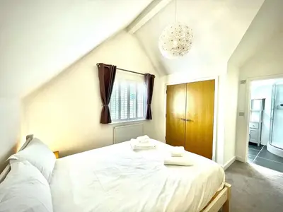 a bedroom with a white bed with towels on it at Trewhiddle Retreat V9 by Together Travel - Luxury 4-Bedroom Villa in St Austell