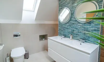 a bathroom with a toilet and a sink and a mirror at Trewhiddle Retreat V9 by Together Travel - Luxury 4-Bedroom Villa in St Austell
