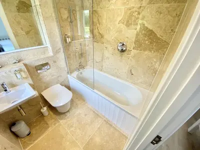 a bathroom with a tub and a sink and a toilet at Trewhiddle Retreat V9 by Together Travel - Luxury 4-Bedroom Villa in St Austell