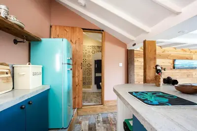 a kitchen with a blue refrigerator in a room at The Olde Piggery, on the coast, Zennor, St Ives in Zennor