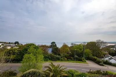 an empty road in a residential neighborhood with the ocean at 10 Boskenza Court in Carbis Bay