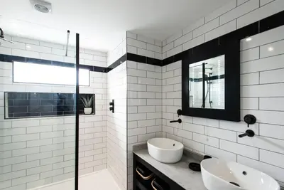 a bathroom with two sinks and a tub and a mirror at 10 Boskenza Court in Carbis Bay
