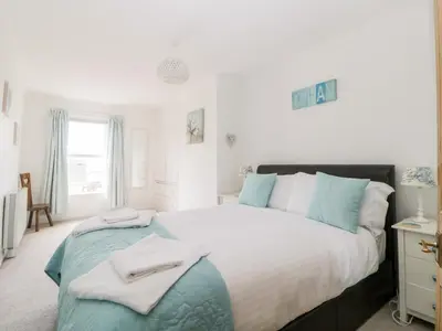 a bedroom with a large bed with towels on it at Meledor in Marazion
