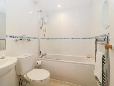 a bathroom with a toilet and a tub and a sink at Meledor in Marazion
