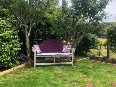 a bench with a purple blanket sitting in the grass at Little Valley View in Otterham