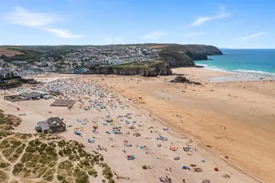 a beach with a large group of people on it at 5 The Dunes in Perranporth