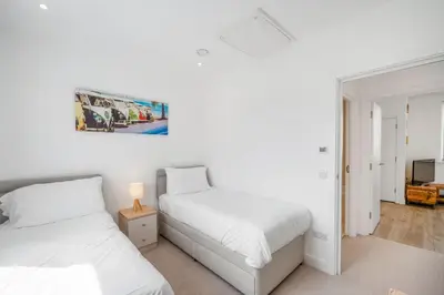 two beds in a room with white walls at 5 The Dunes in Perranporth