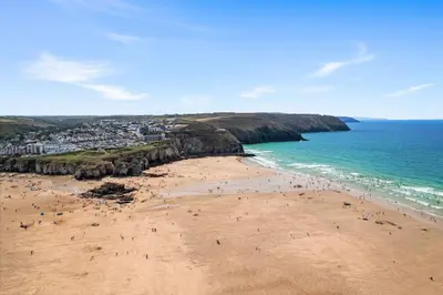 a group of people on a beach near the ocean at 5 The Dunes in Perranporth