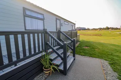 a porch of a house with a fence and a plant at Chantry Lodge in Newquay