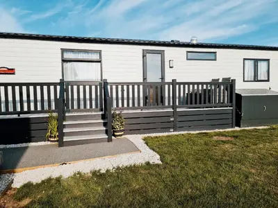 a house with a wooden fence and a porch at Chantry Lodge in Newquay