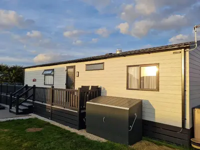 a mobile home with a porch and a deck at Chantry Lodge in Newquay