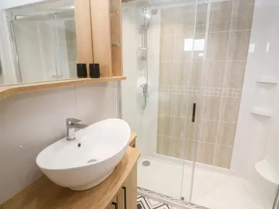 a bathroom with a white sink and a shower at Chantry Lodge in Newquay