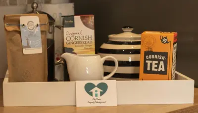 a box with a cup of tea and a box of coffee at Coastguard Cottage Cornwall - Sea & Harbour Views in Mevagissey