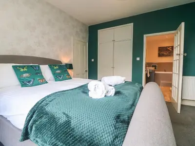 a bedroom with a bed with towels on it at Gweek House in Helston