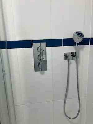 a shower in a bathroom with a shower head at Sirens Sunset Peaceful Retreat with stunning sea views, 5 minutes from Porth Beach in Newquay